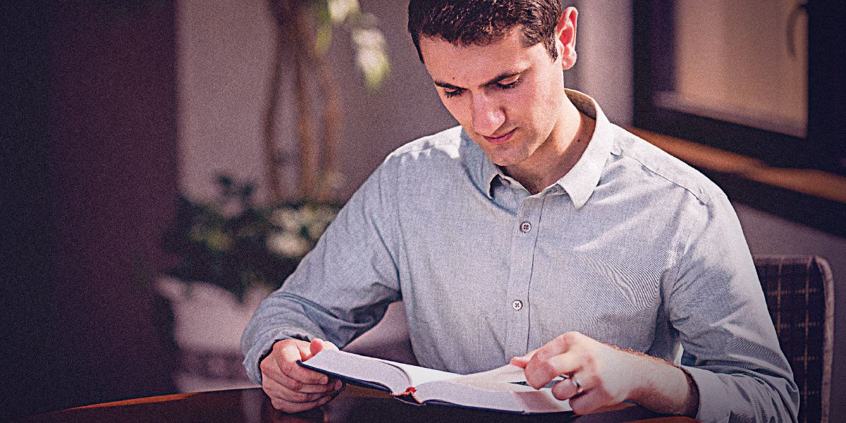 Un hombre copiando un manuscrito de la Biblia