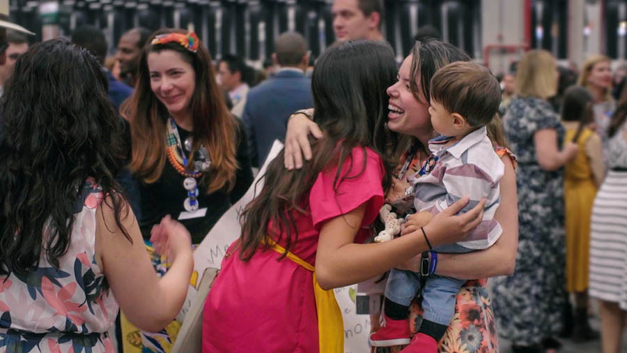 Picture from the video ‘‘Love No De Ever Fail’! International Conventions.’ Brothers and sisters from other country and the ones for the country de hug and greet each other for international convention.
