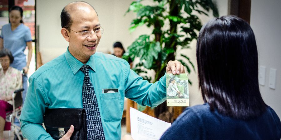 UJonathan unikeza umuntu osebenza etafuleni lokwamukela abafikayo ipheshana ePhilippines